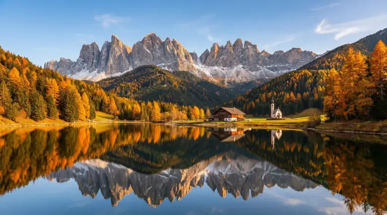 Paesaggio autunnale in Trentino con lago, boschi colorati e montagne sullo sfondo