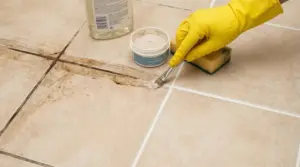 Pulizia delle fughe scure di un pavimento con un pennello e prodotto specifico